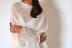 Off white poncho, ivory mohair pullover, bridal mohair cardigan, soft mohair silk sweater, wedding soft sweater, handmade knitted pullover This women's off white poncho is of loose knit, versatile, easy to wear and to look after, comfortable. Knitted shawl poncho made of pure mohair-silk is a perfect choice for any occasion. It can be worn as a summer scarf, beach cover up, an evening shawl or an oversize sweater. Knitted sleeves are separate. Can be used as a knit sleeve or as a separate wrist. Wedding Sweater, Knitted Sleeves, White Poncho, Sweater Handmade, Bridal Shrug, Evening Shawls, Silk Sweater, Oversize Pullover, Shrugs And Boleros