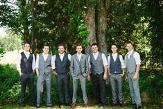 a group of young men standing next to each other in front of a large tree