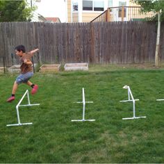 a young boy is jumping over an obstacle in the yard