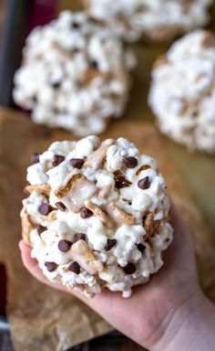 a hand holding a cookie with chocolate chips and marshmallows