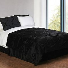 a black and white bed in a bedroom next to a window