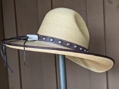 The Elsa Gus Palm hat has a golden hue. The brim is trimmed in brown grosgrain. Distressed leather has been simply decorated and the back has a deer antler bead. The brim measures 4" and the crown is 5 1/2". It's a very soft and comfortable hat. Note: Please allow 3-4 weeks. Rustic Adjustable Felt Hat For Kentucky Derby, Brown Curved Brim Hat Bands For Kentucky Derby, Elegant Brown Hat Band For Ranch, Brown High Crown Hat For Western-themed Events, Brown High Crown Hat For Rodeo, Adjustable Fedora With Short Brim For Riding, Western Leather Hat Bands For Kentucky Derby, Adjustable Leather Hat Bands For Kentucky Derby, Adjustable Short Brim Fedora For Riding