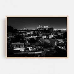 a black and white photo of the city at night with buildings in the foreground