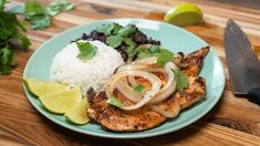 a blue plate topped with chicken, rice and cilantro