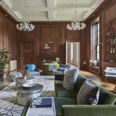 a living room filled with furniture and lots of wood paneled wallpaper on the walls