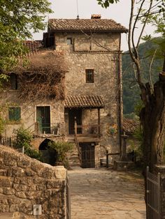 an old stone building with ivy growing on it's roof and stairs leading up to the entrance