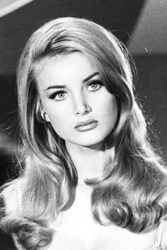 an old black and white photo of a woman with long blonde hair wearing a dress