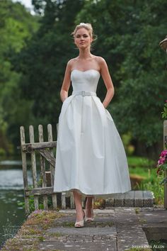 a woman in a white dress standing on a bridge