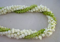 white flowers with green leaves are arranged in a circle