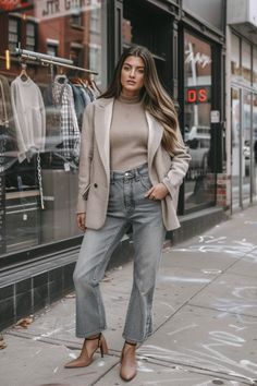 a woman standing on the sidewalk in front of a store window wearing high rise jeans