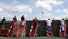 several people standing on top of red barriers