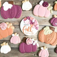 decorated cookies are arranged on a wooden surface with the words happy fall written in white