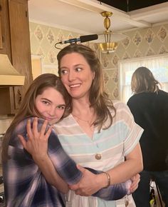 two women hugging each other in the kitchen