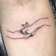 a tattoo on the leg of a person with a hand holding a bird in it