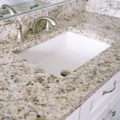 a bathroom sink sitting under a mirror next to a faucet mounted on a wall