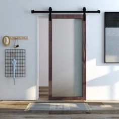 an open door in a white room next to a wall clock and coat rack with hooks