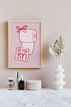 a bathroom with a pink wall and white marble counter top next to an art piece