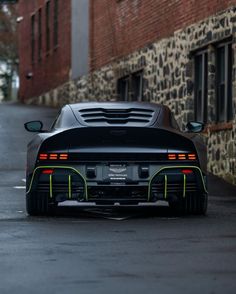 a black sports car parked in front of a brick building