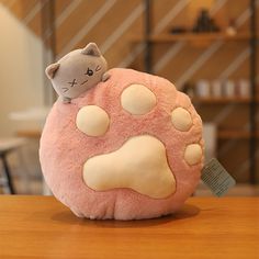 a pink stuffed animal sitting on top of a wooden table