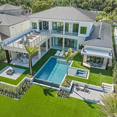 an aerial view of a large house with a pool in the yard and lawn area