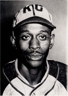 an old black and white photo of a man wearing a baseball cap with the word ok on it