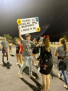 a group of people standing around each other holding up a sign that reads perks of being waterflower 1 noc w me