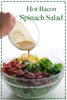 a person pouring dressing over a salad in a bowl with lettuce and bacon