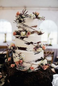 a wedding cake with flowers and branches on top