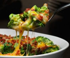 broccoli, bacon and cheese casserole being lifted from a white bowl