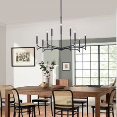 a dining room table with chairs and a chandelier hanging from the ceiling above it