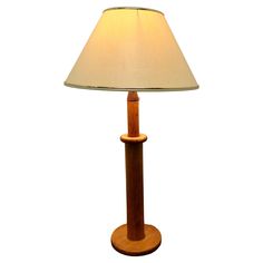 a wooden table lamp with a beige shade on it's base and a white linen lampshade