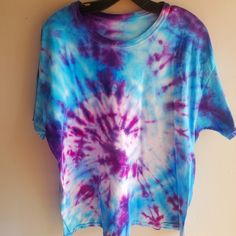 a blue and purple tie - dyed shirt hanging on a wall