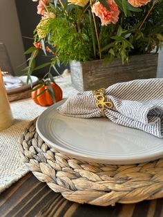 there is a place setting with flowers in the vase and napkins on the plate