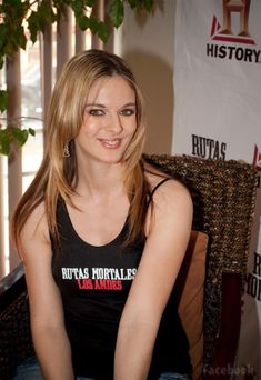 a woman sitting in a chair smiling at the camera