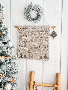 a small christmas tree next to a wall hanging