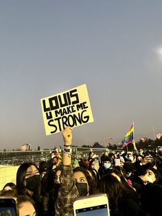 a group of people holding up signs and cell phones