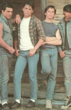 four young men standing in front of a building