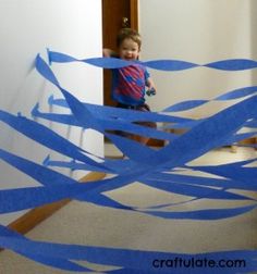 a young boy is standing on the stairs with blue streamers in front of him