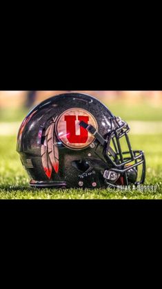 a football helmet sitting on top of a field with the letter i painted on it