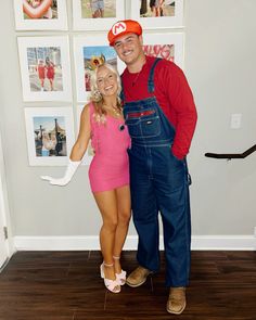 a man and woman in overalls standing next to each other with pictures on the wall behind them