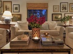 a living room filled with lots of furniture and flowers on top of a coffee table