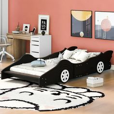 a child's bedroom with pink walls and white furniture, including a black car bed