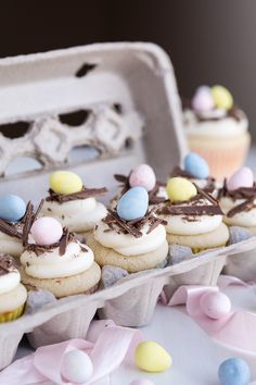 some cupcakes are sitting on a tray with eggs and chocolate sprinkles