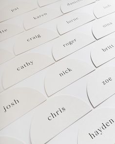 many white business cards with names on them are arranged in the shape of heart shapes