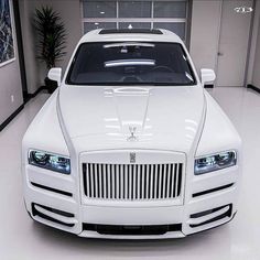 a white rolls royce parked in a garage