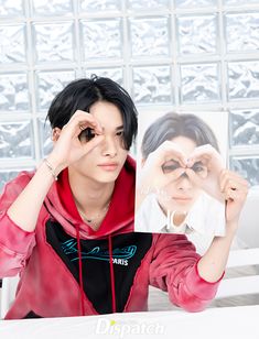 a woman sitting at a table holding up a photo with her hands to her face