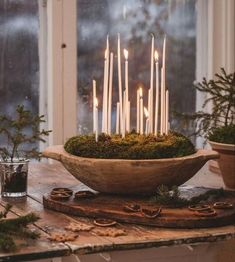 a bowl filled with candles sitting on top of a table