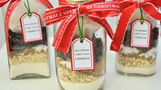 three mason jars filled with cookies and granola, tied with red ribbon for christmas