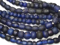 several blue and black beads on a white surface