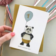 a hand holding a card with a panda bear on it and the number one balloon